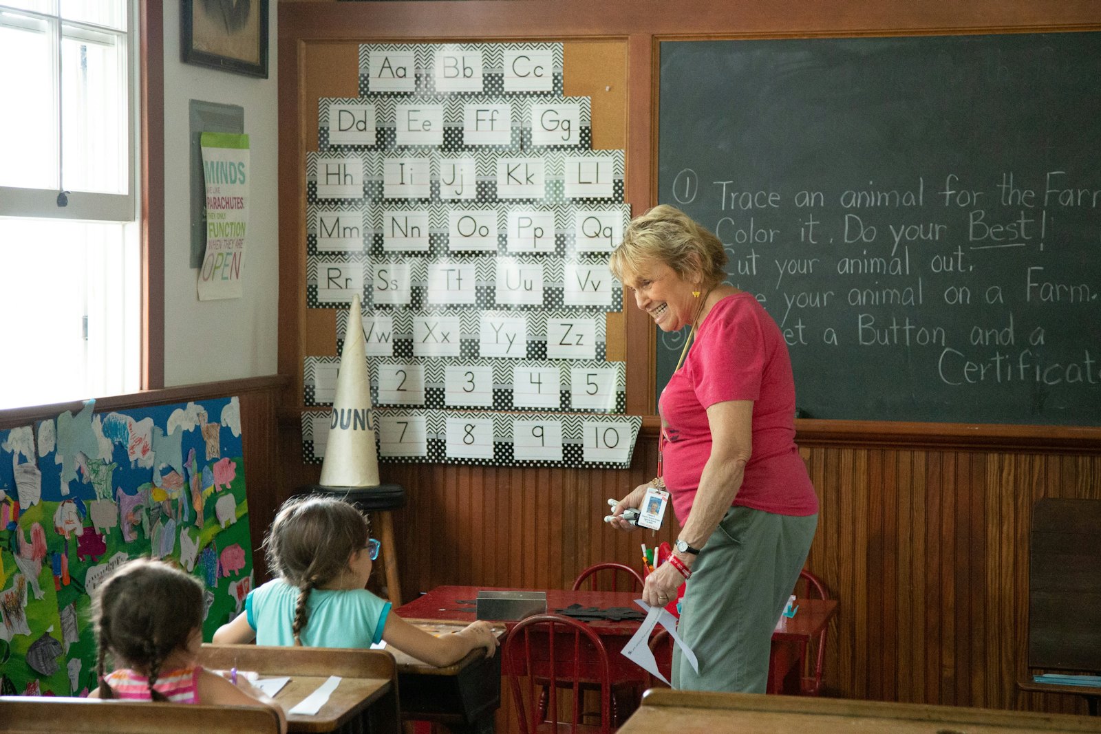 An educator with children at a classroom chalkboard